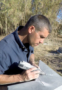 Artist Itai Chazan at work dremmeling the stone piece. 