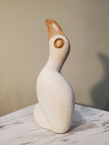 A beautiful perched white pelican looking inquisitively upward. This bird was sculpted from a single piece of opal stone. The white bird is accentuated by a bronze colored beak and eyes. Colors included: White, Bronze.