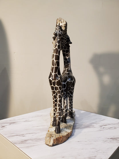 Two giraffes eating from a tree. The giraffes have a beautiful pattern of brown circles outlined in white. Colors include: Brown, White, Tan.