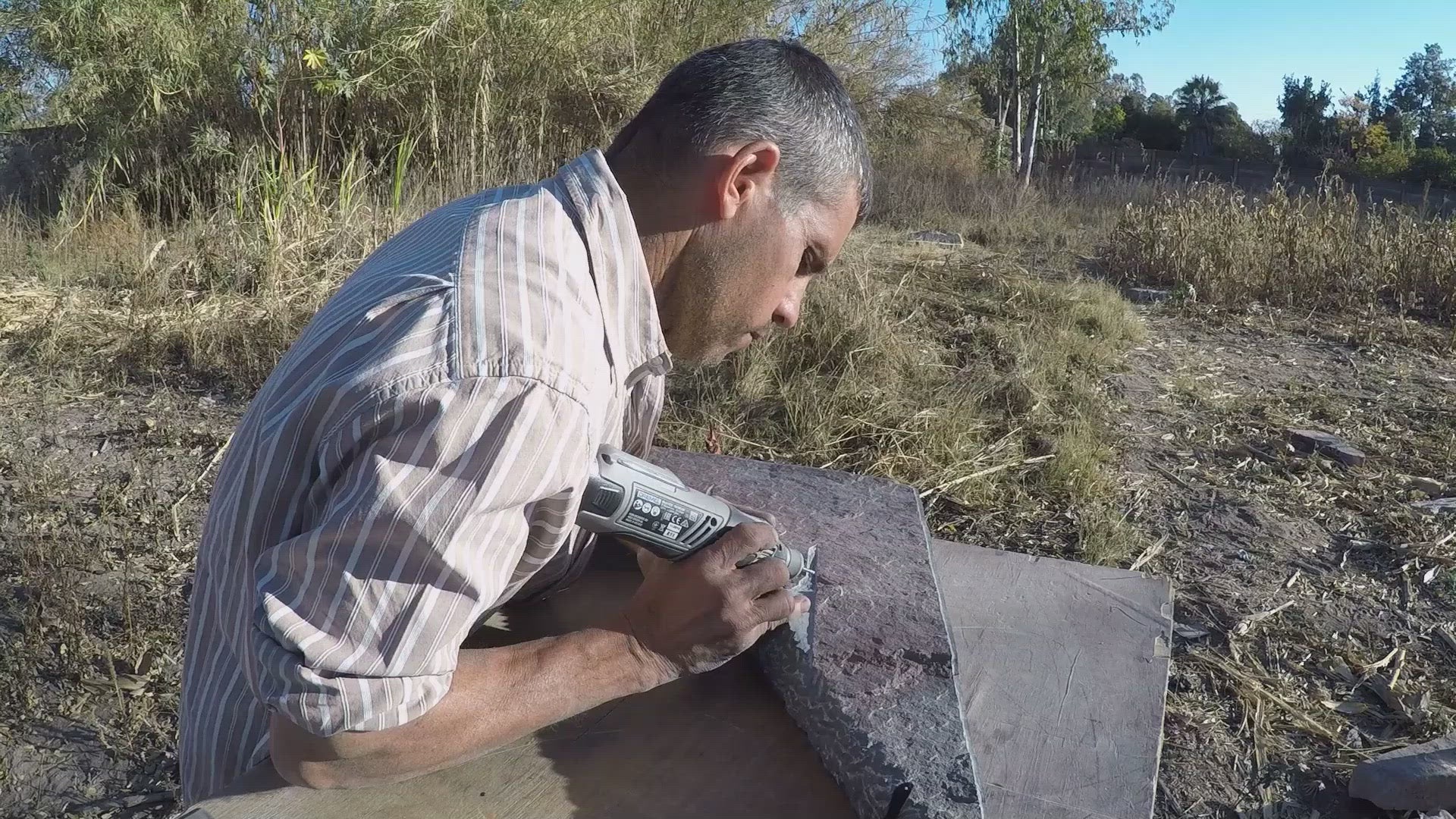 Artist Itai Chazan at work dremmeling the stone piece. 